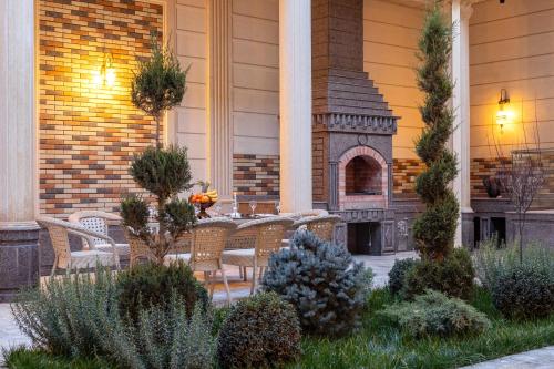 Un patio al aire libre con una mesa y una chimenea. en Osiyo Plaza Hotel, en Samarkand