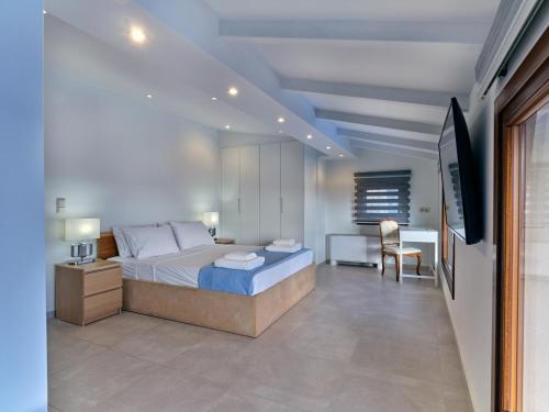 a bedroom with a bed and a desk and a television at Forecastle in Keratea