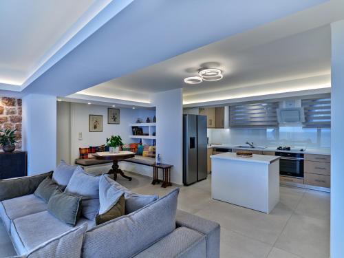 a living room with a couch and a kitchen at Forecastle in Keratea