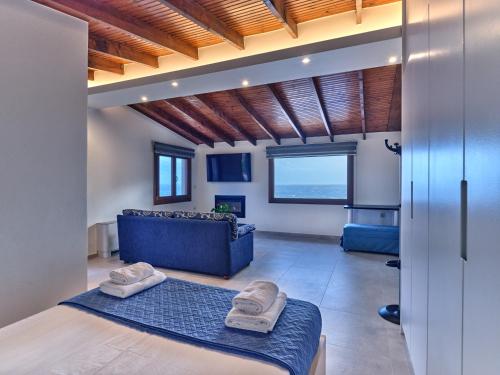 a bedroom with a blue bed and a blue couch at Forecastle in Keratea