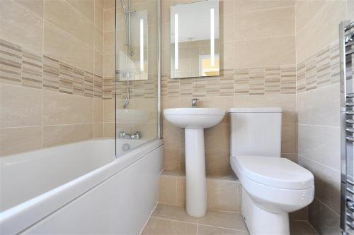 Un baño con inodoro, lavabo y bañera. en The Old Bakehouse, en Lyme Regis