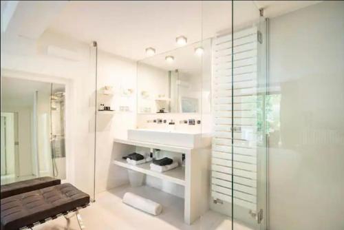 ein Badezimmer mit Waschbecken und Glasdusche in der Unterkunft Villa Alesia in Paris