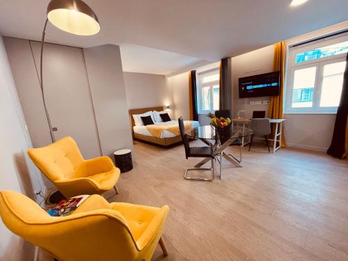 Living Funchal Executive في فونشال: غرفة معيشة مع كراسي صفراء وغرفة نوم