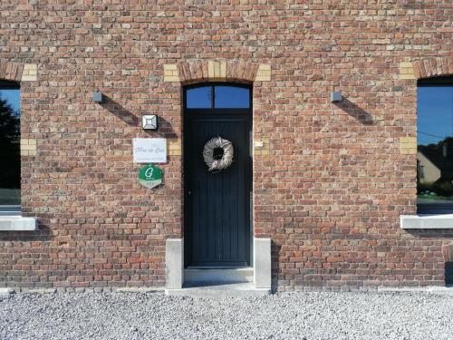 a black door with a wreath on the side of a brick building at Gite Terre de ciel in Ferrières