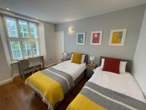 a bedroom with two beds and a window at Fuchsia Cottage in Flushing