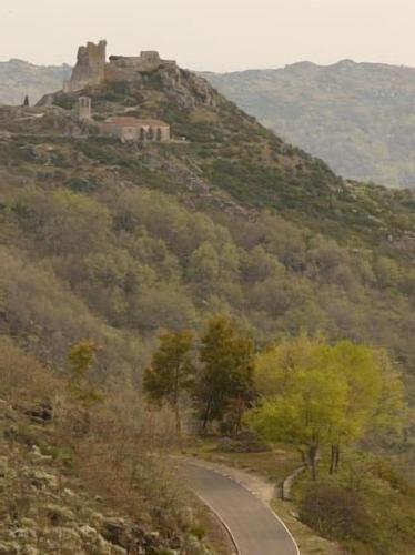 a winding road on a hill with a castle on it at Apartamentos en sierra de gata ALMA in Villamiel