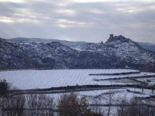 a snow covered hill with a castle on top of it at Apartamentos en sierra de gata ALMA in Villamiel