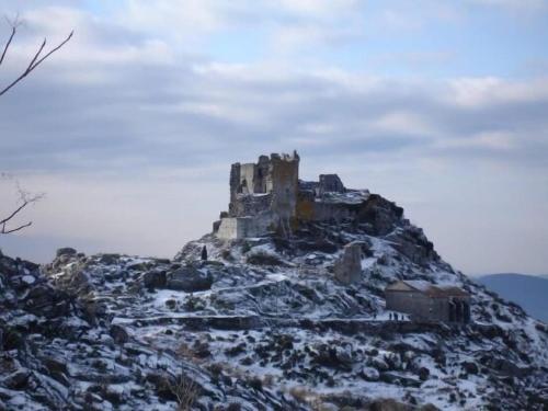 a castle on top of a mountain in the snow at Apartamentos en sierra de gata ALMA in Villamiel