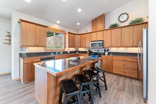 a kitchen with wooden cabinets and a large island with bar stools at Connect with the Columbia in Orondo