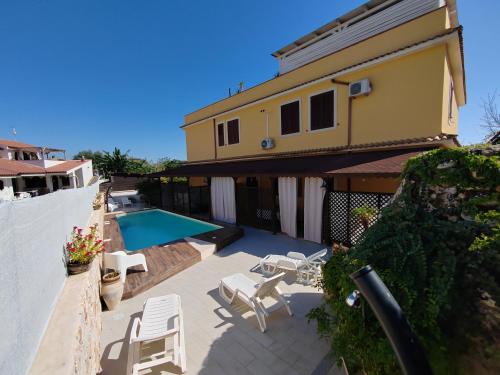 a patio with a swimming pool and a house at villa xenia in Avola