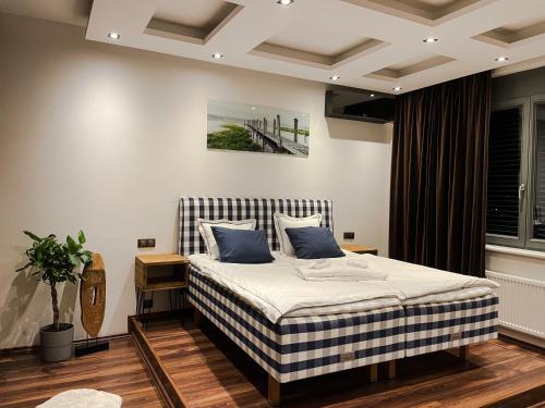 ein Schlafzimmer mit einem großen Bett mit blauen Kissen in der Unterkunft Apartment Lupáčova in Prag