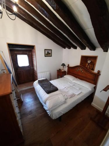 um quarto com uma cama grande num sótão em Cabaña Pasiega La Quemada em San Pedro del Romeral