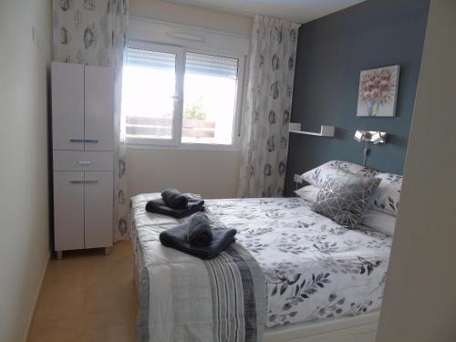 1 dormitorio con 1 cama con toallas en Los Dolses, Villamartin 2 bed Apartment with communal pool, en Los Dolses