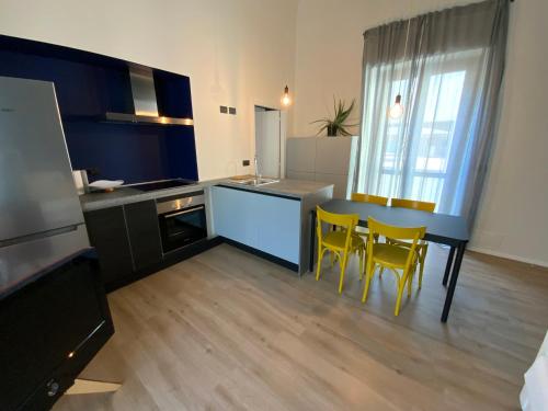a kitchen with a table and yellow chairs in it at #DavVeroCasa - Appartamento con terrazzo in centro in Biella