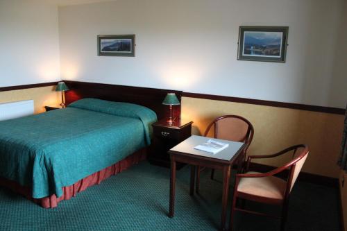 A bed or beds in a room at The Weigh Inn Hotel & Lodges