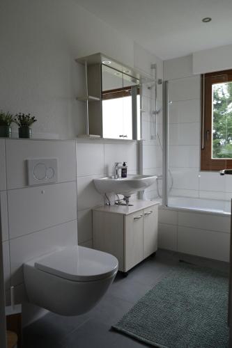 a bathroom with a toilet and a sink and a tub at Ferienwohnung Casa Bella 