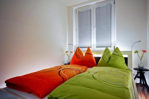 łóżko z kolorowymi poduszkami w sypialni w obiekcie Apartment Giuliano Vienna w Wiedniu