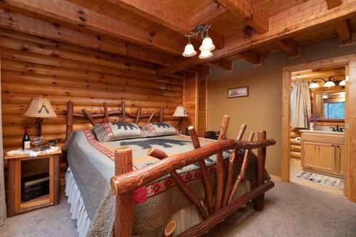 een slaapkamer met een bed in een blokhut bij Smoke Rise Lodge · Lake Front, Luxury Cabin, Hot Tub, in Dandridge