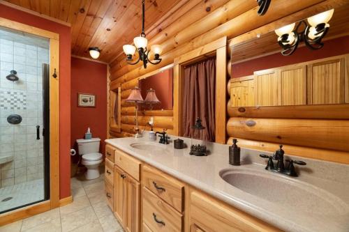 a bathroom with two sinks and a shower in a log cabin at Smoke Rise Lodge · Lake Front, Luxury Cabin, Hot Tub, in Dandridge