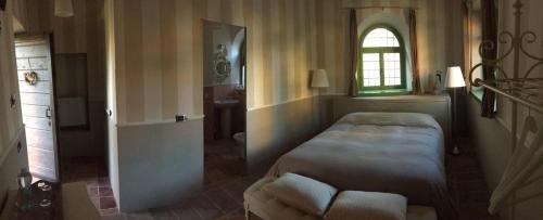 a bedroom with a bed and a window and a couch at B&B San Martino in Mede