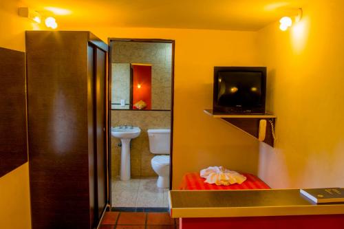 uma casa de banho com WC e uma televisão em Hotel Villa Sol em Merlo