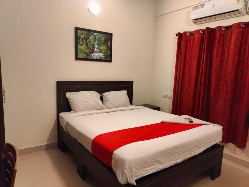 a bedroom with a bed with a red curtain at Pristine Inn Manyata in Bangalore