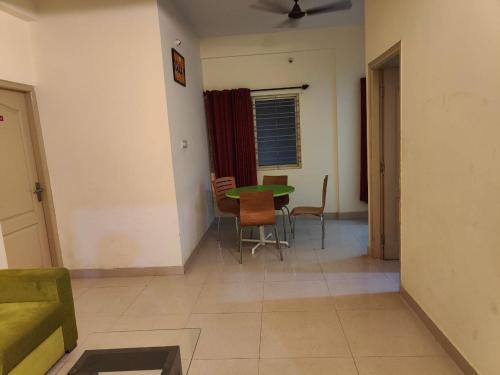 a living room with a green table and chairs at Pristine Inn Manyata in Bengaluru
