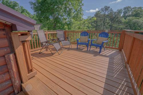 a wooden deck with chairs and a table on it at Smoke Rise Barn · Great Lake Front, Large Dock, 4bdrm, Pool Table in Dandridge