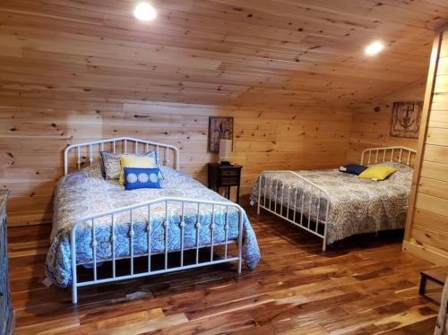 Duas camas num quarto de madeira com paredes de madeira em Smoke Rise Barn · Great Lake Front, Large Dock, 4bdrm, Pool Table em Dandridge