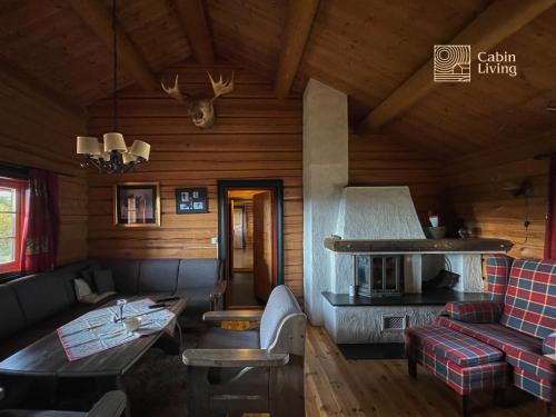 a living room with a couch and a table at Cozy cabin at Beitostølen with sauna, hot tub & fireplace in Beitostøl