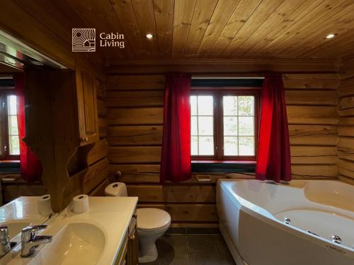 a bathroom with a tub and a sink and a toilet at Cozy cabin at Beitostølen with sauna, hot tub & fireplace in Beitostøl
