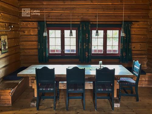 un comedor con una gran mesa de madera y sillas en Solid and cozy cottage in a secluded location, en Beitostølen