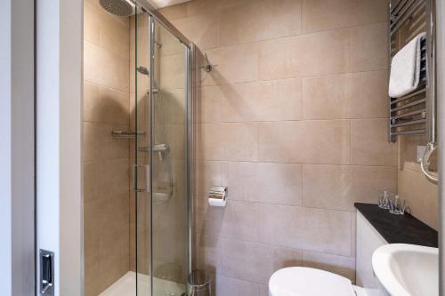 a bathroom with a shower and a toilet and a sink at Surrey Lodge in Brockenhurst