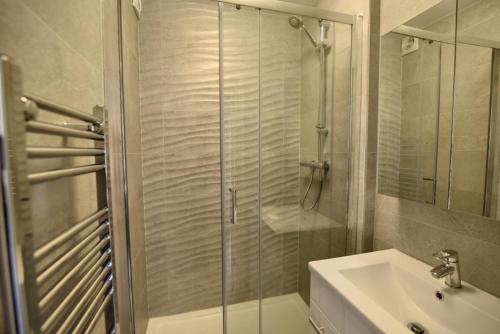 uma casa de banho com um chuveiro e um lavatório. em Little Gem em Lyme Regis