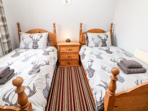 - une chambre avec 2 lits jumeaux et une table de nuit dans l'établissement Haddon Cottage, à Bakewell