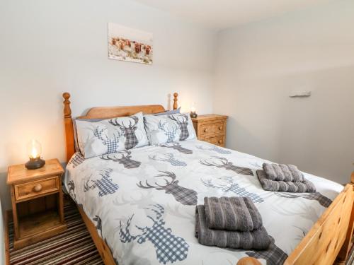 Schlafzimmer mit einem Bett mit blauer und weißer Decke in der Unterkunft The Tom Wragg Suite in Bakewell
