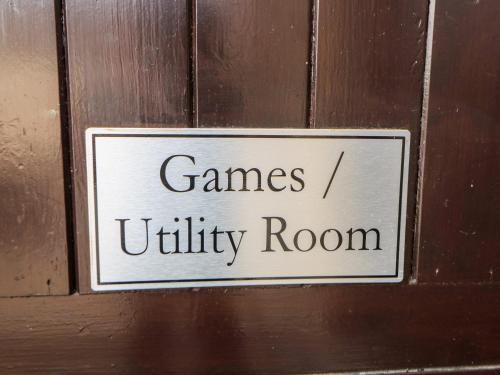 a sign on a wooden door that reads games utility room at The Tom Wragg Suite in Bakewell