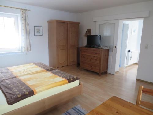 a bedroom with a bed and a dresser and a television at Apartment Deller Renate in Leutschach