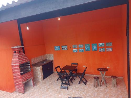 una stanza con camino, tavolo e sedie di Casa com piscina em Mongaguá a Mongaguá