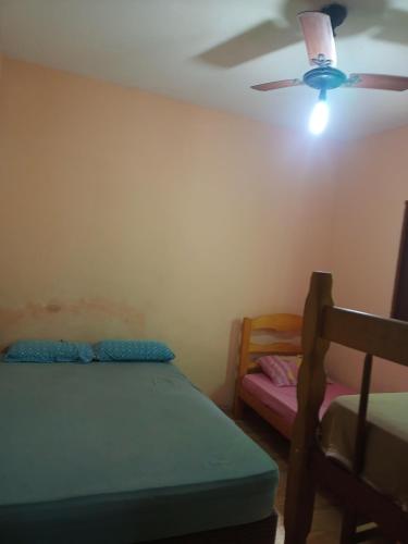 a bedroom with a bed and a ceiling fan at Casa com piscina em Mongaguá in Mongaguá