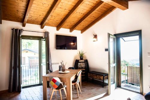 a living room with a wooden table and a balcony at B & B CA’ D’ OLINA in Pavullo nel Frignano