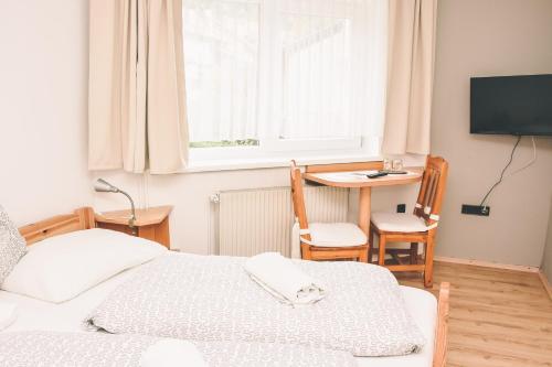 1 dormitorio con cama, mesa y ventana en Pension s'Platzl Stuhleck en Spital am Semmering