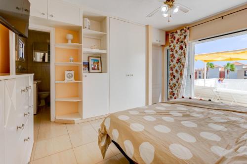 Ocean View Duplex Tenerife ( Golf del Sur) في سان ميغيل ذي أبونا: غرفة نوم بسرير ونافذة كبيرة