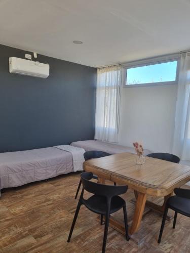 a room with a table and chairs and a bed at La Cañada Chascomús in Chascomús