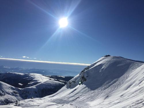 a snow covered mountain with the sun in the sky at Tannerhof Bed & Breakfast in Caines