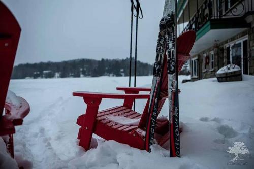 a red bench in the snow next to a building at Gauthier's Saranac Lake Inn in Saranac Lake