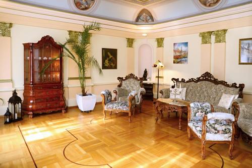 a living room with chairs and a table at Luxusní apartmán s empírovými freskami v centru Čáslavi in Čáslav
