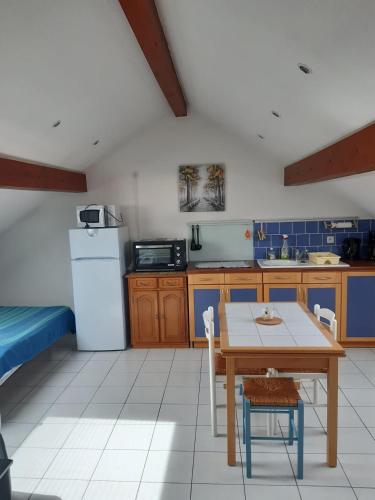 Il comprend une cuisine équipée d'une table et d'un réfrigérateur. dans l'établissement La familia, à Gérardmer