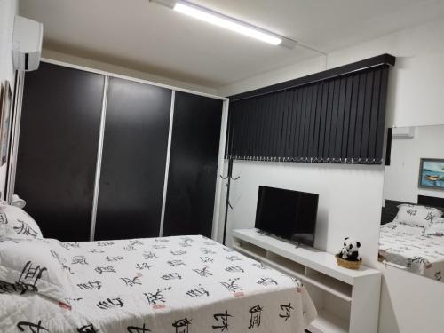 1 dormitorio con 1 cama y TV de pantalla plana en Pousada Interpraias, en Balneário Camboriú