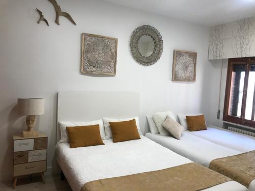 two beds in a room with white walls at Claustro Las Francesas siglo XV in Valladolid
